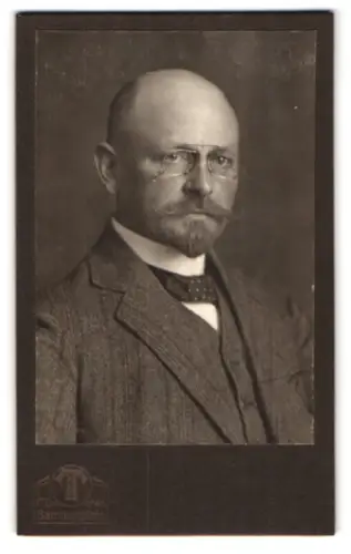 Fotografie Hermann Tietz, München, Bahnhofplatz, Porträt eines Mannes mit Brille