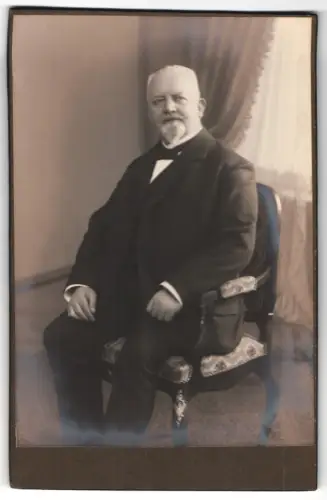 Fotografie unbekannter Fotograf und Ort, Herr im Anzug auf Stuhl sitzend