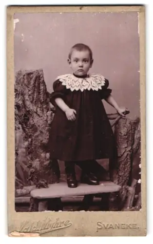 Fotografie Vald. Myhre, Svaneke, Kleinkind in dunklem Kleid