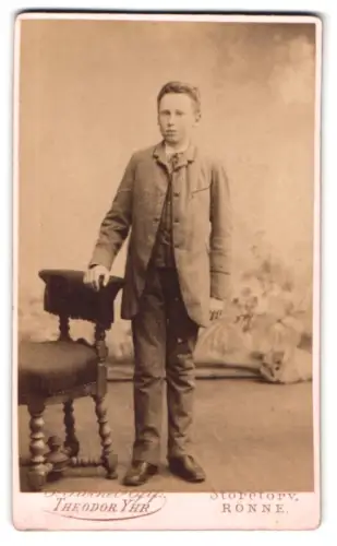 Fotografie G. Stöckel`s Eftf. Theodor Yhr, Rønne, Storetorv, Junge im Anzug neben Stuhl
