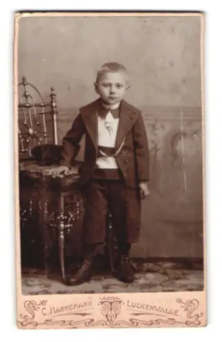 Fotografie C. Hannemann, Luckenwalde, Trebbinerstrasse 6, Junge mit Mütze bei einem Stuhl