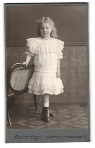 Fotografie Atelier Kegel, Elberfeld, Herzogstrasse 32, Mädchen im weissen Kleid neben Stuhl