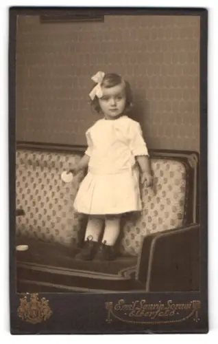 Fotografie Emil Saurin Sorani, Elberfeld, Königstr. 64, Kind auf gepolstertem Sofa