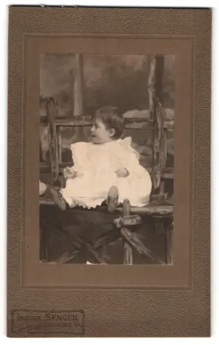 Fotografie Senger, Braunlage i.H., Kind auf rustikaler Bank