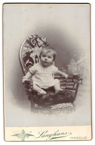 Fotografie Langhans, Prag, Wassergasse 37, Porträt eines Kleinkinds auf einem dekorativen Stuhl