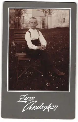 Fotografie unbekannter Fotograf und Ort, Junge auf Gartenstuhl im Freien