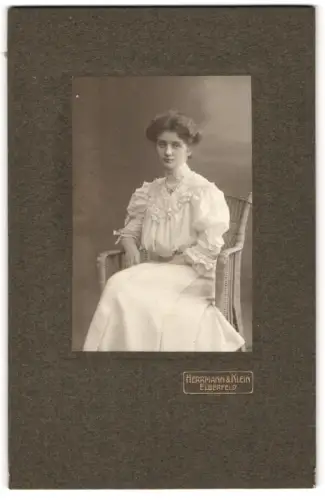 Fotografie Herrmann & Klein, Elberfeld, Elegante Dame im Korbsessel