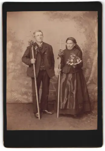 Fotografie unbekannter Fotograf und Ort, Paar mit Blumen und Kreuzen