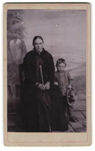 Fotografie A. Lidauer, Ort unbekannt, Frau mit Kind vor malerischem Hintergrund