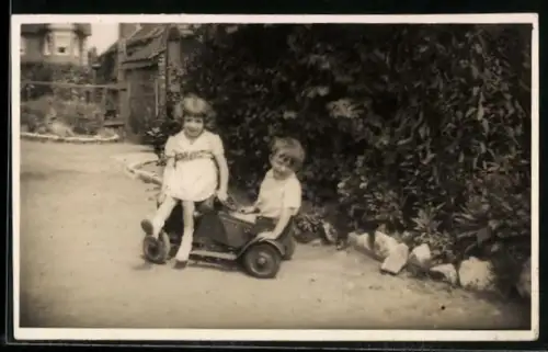 Foto-AK Zwei Kinder auf einem Spielzeugauto