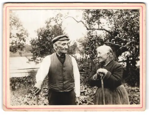 Fotografie unbekannter Fotograf und Ort, Älteres Paar zusammen im Garten