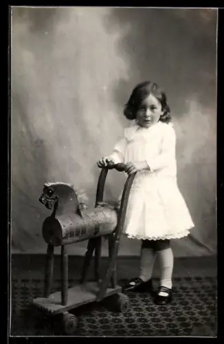 AK Kleines Mädchen mit Spielzeugpferd, Schaukelpferd