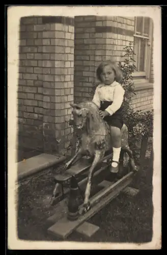 Foto-AK Mädchen auf Spielzeugpferd, Schaukelpferd