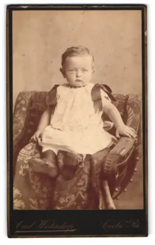 Fotografie Carl Westendorp, Köln, Comödien-Strasse No 7, Porträt eines Kleinkindes auf einem gepolsterten Stuhl