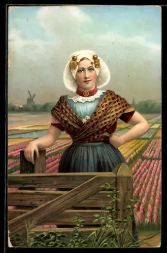 AK Zeeland, niederländische Frau in Tracht vor einer Tulpenwiese