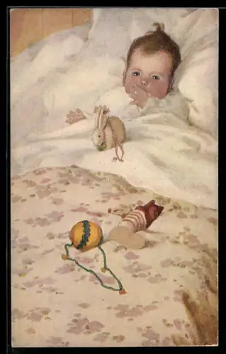 Künstler-AK Vom Christkindl, Baby`s first Christmas, Baby liegt im Bett mit Spielzeugkaninchen und weiterem Spielzeug