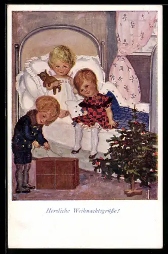 AK Herzliche Weihnachtsgrüsse, drei kleine Kinder öffnen ein Paket vor dem Weihnachtsbäumchen, Bescherung