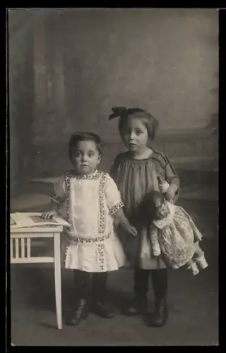 AK Zwei Kinder neben einem Tisch mit Käthe Kruse-Puppe