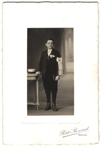 Fotografie Petit-Renaud, Nantes, Junge in adretter Kleidung mit Hut auf Tisch