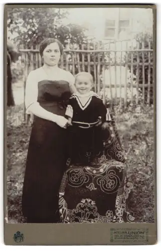 Fotografie Atelier Union, Schmiedeberg, Frau mit Kind vor Gartenzaun