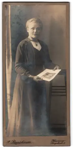 Fotografie F. Renziehausen, Hannover, Lange Laube 2, Frau mit Foto in den Händen