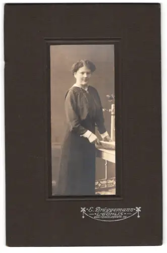 Fotografie E. Brüggemann, Gohlis, Breitenfelderstr. 99, Frau an einem Tisch stehend
