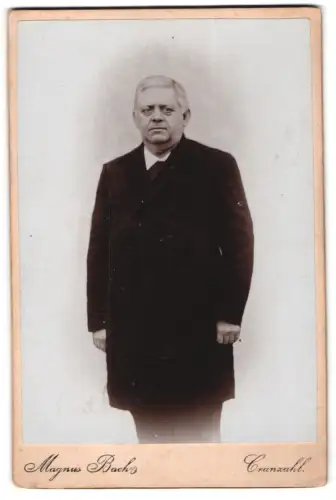 Fotografie Magnus Bach, Cranzahl, Mann in dunklem Mantel