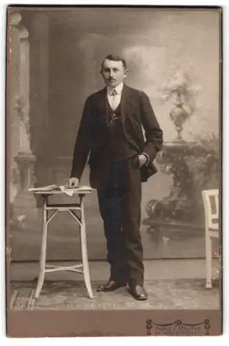 Fotografie Franz J. Mauthe, Balingen, Mann in Anzug mit Tisch