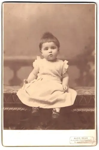 Fotografie Alois Beer, Klagenfurt, Sitzendes kleines Kind in weissem Kleid