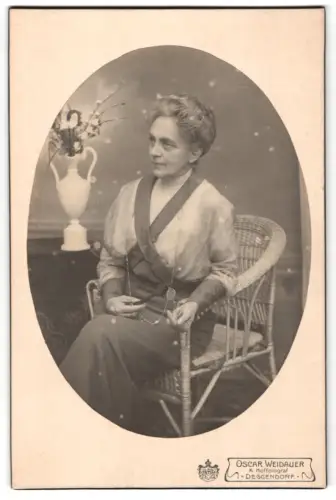 Fotografie Oscar Weidauer, Deggendorf, Dame auf einem Korbstuhl mit Brille