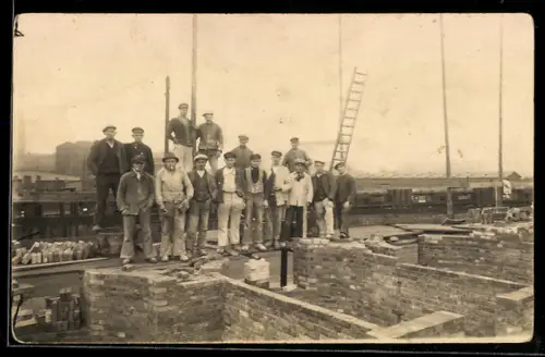 Foto-AK Maurer in Arbeitskleidung im Gruppenbild bei einem Haus