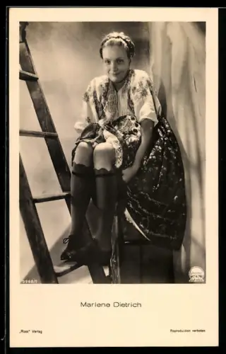 AK Schauspielerin Marlene Dietrich in Tracht einem Hocker sitzend