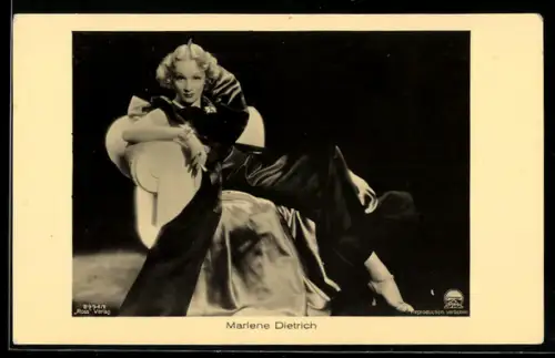AK Schauspielerin Marlene Dietrich in dunklem Kleid auf einem Sessel sitzend