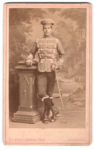 Fotografie G. J. Koch, Schleswig, Lollfuss 118-120, Soldat der Husaren in Attila mit Krätzchen und Säbel