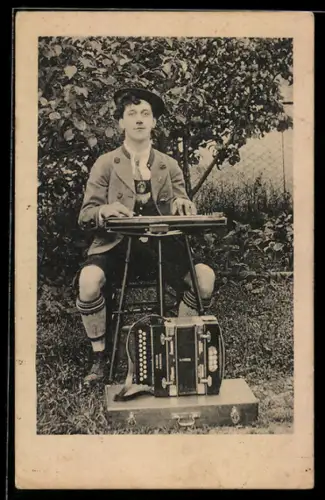 AK Mann in Tracht sitzt vor einem Akkordeon an einer Zither