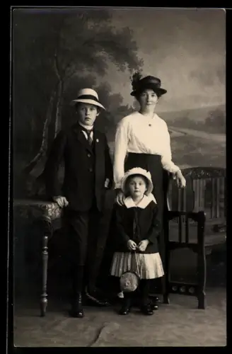 Foto-AK Junge Frau mit zwei Kindern vor einer Landschaft, Studiokulisse