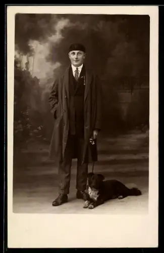 Foto-AK Herr im Mantel mit Hund, Studiokulisse