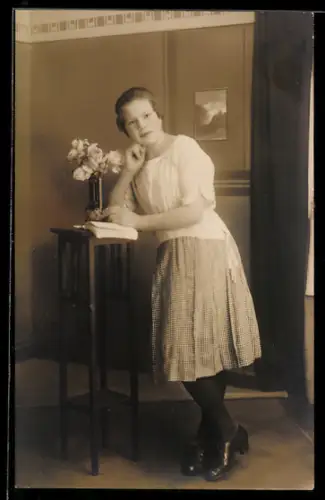 Foto-AK Junge Frau lehnt sich auf hohen Tisch, Studiokulisse