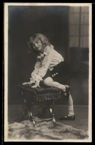 Foto-AK Kleines Mädchen steigt auf einen Hocker, Studiokulisse