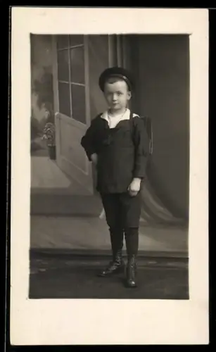Foto-AK Junge im Matrosenanzug mit Schultasche, Studiokulisse