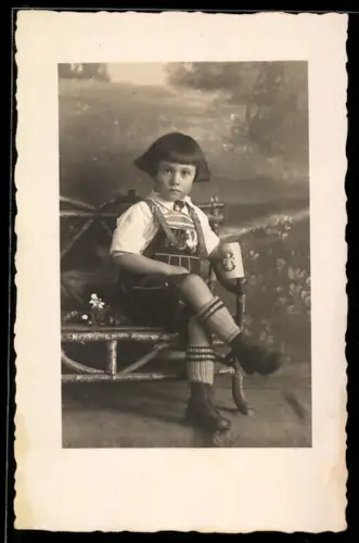Foto-AK Kind in Tracht mit Münchener Bierkrug, Studiokulisse