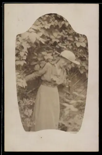 Foto-AK Lächelnde junge Dame vor einer Hecke stehend in schlichtem Passepartout