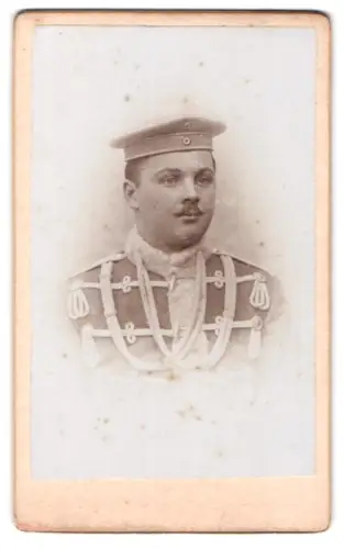 Fotografie Fotograf und Ort unbekannt, Husar in Attila mit Krätzchen und Überjacke