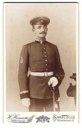 Fotografie H. Hermestroff, Saarlouis, Silberherzstr. 13, Uffz. der Artillerie in Uniform mit Schirmmütze und Säbel