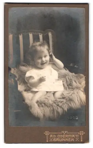 Fotografie Ad. Odermatt, Brunnen, Kleinkind auf einem Sessel