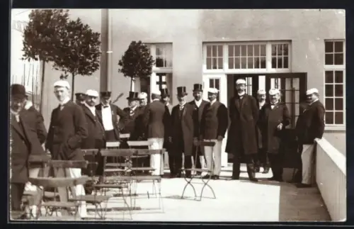 Foto-AK Eggesin, Bahnhof, Herrengruppe mit Schiebermützen u. Zylindern auf einer Terrasse