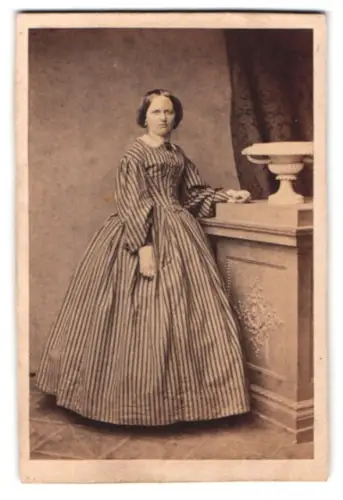 Fotografie C. Pohlmann, Magdeburg, Frau in gestreiftem Kleid neben Säule