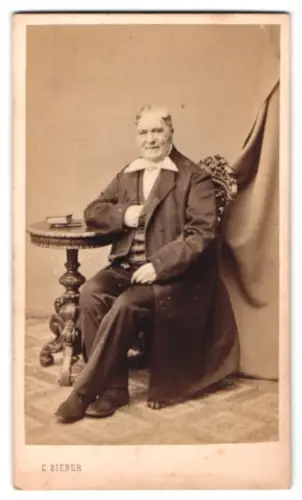 Fotografie E. Bieber, Hamburg, Gr. Bäckerstrasse 26, Älterer Herr am Tisch sitzend