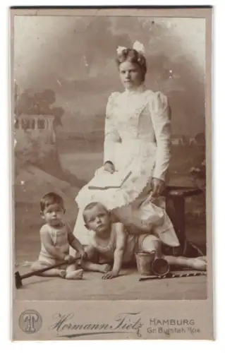 Fotografie Hermann Tietz, Hamburg, Gr. Burstah 12/14, Kinder mit Strandspielzeug und Frau mit Buch