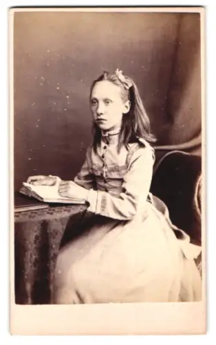 Fotografie A. McGregor, Kilmarnock, King Street 46, Mädchen mit Buch an einem Tisch sitzend